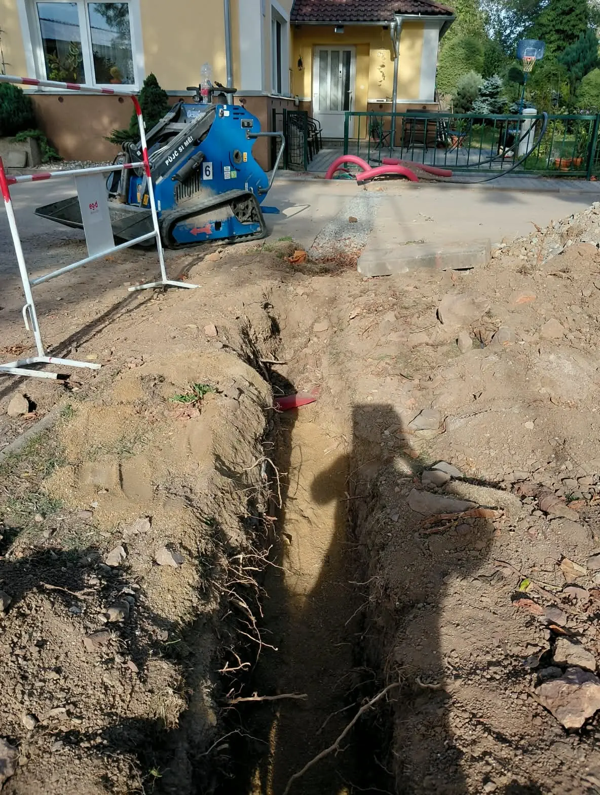 Otevřený výkop před rodinným domem, před uložením chráničky