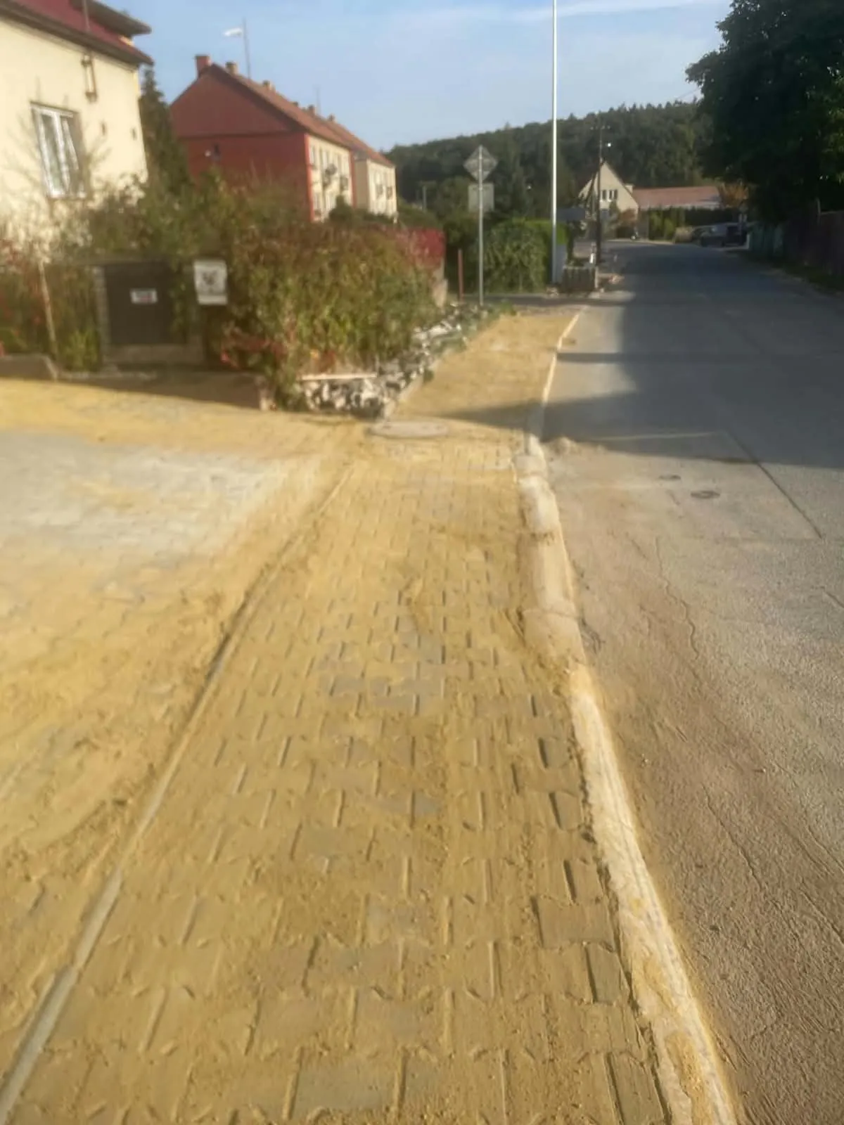 Nový chodník ze zámkové dlažby zasypaný pískem