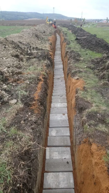 Dlouhá rýha v poli, na dně betonové desky