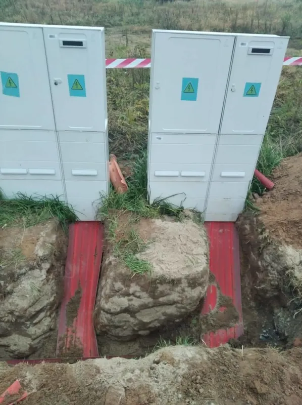 Dva elektroměrové rozvaděče, pod nimi rýha s kabelem v červené fólii